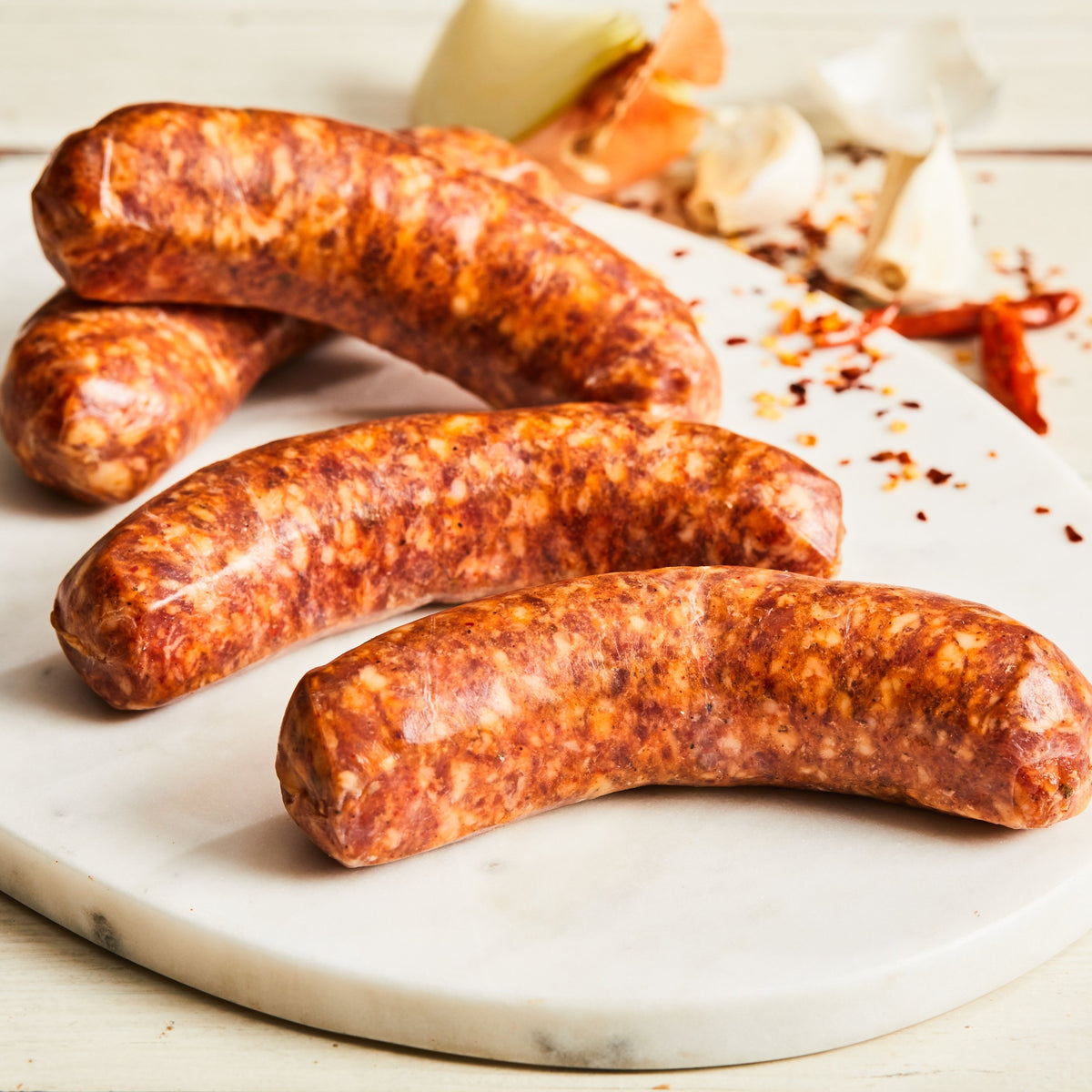 Image of Hot Italian sausage. 4 links, about 1 lb. a fresh, uncooked Italian pork sausage made with toasted fennel seed, coriander, black pepper, garlic, oregano, roasted red pepper, and Calabrian chili