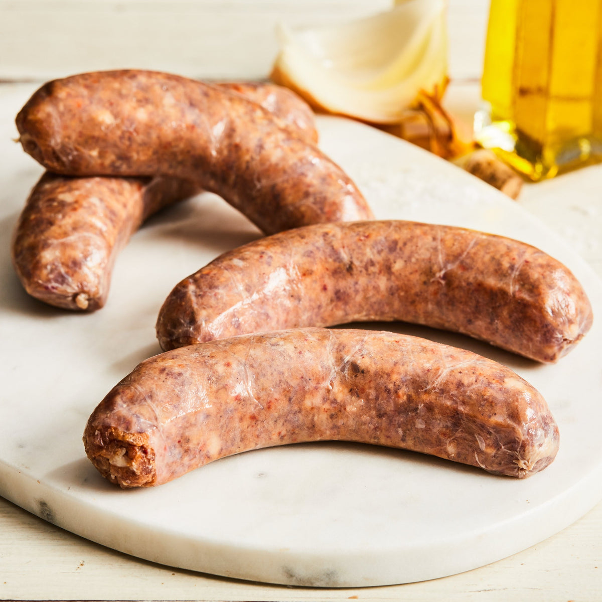 Image of Sweet Italian sausage. 4 links, about 1 lb. an uncooked Italian-style pork sausage made with toasted fennel seed, coriander, black pepper, garlic, red onion jam, and pancetta